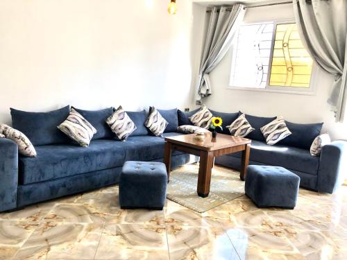 - un salon avec un canapé bleu et une table dans l'établissement Padova Surf House, à Imsouane