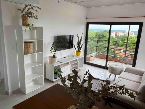 a living room with white furniture and a large window at Apartamento 2 habitaciones en Asunción. in Asunción