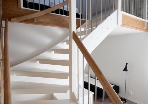 a staircase in a house with white walls and wood at Hotell Havsporten in Karlholmsbruk