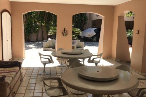 2 Tische und Stühle im Wohnzimmer in der Unterkunft Um sonho de casa frente à laguna in São Pedro da Aldeia