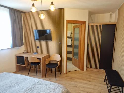 a bedroom with a bed and a desk and chairs at Pri štorklji in Moravske Toplice