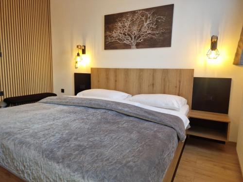 a bedroom with a large bed with a wooden headboard at Pri štorklji in Moravske Toplice