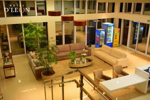 a lobby with couches and plants in a building at Hotel D'Leon in Gurupi