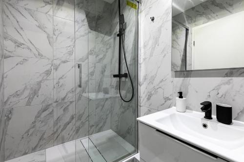 a white bathroom with a shower and a sink at Studio hyper centre in Strasbourg