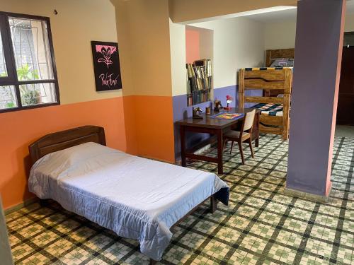 a bedroom with a bed and a desk and a table at El Pueblito in Cochabamba