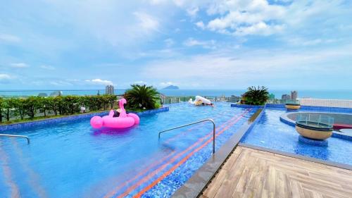a large swimming pool with a pink inflatable raft at 光嶼海溫泉海景無邊際泳池豪華套房 in Hsin-hsing