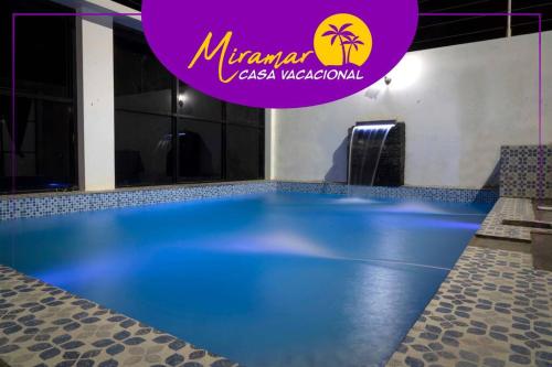ein großer Pool mit einem lila Schild darüber in der Unterkunft MIRAMAR Casa Vacacional Frente al mar in Tonsupa