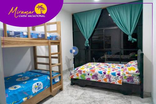 1 Schlafzimmer mit 2 Etagenbetten und 1 Bett in der Unterkunft MIRAMAR Casa Vacacional Frente al mar in Tonsupa