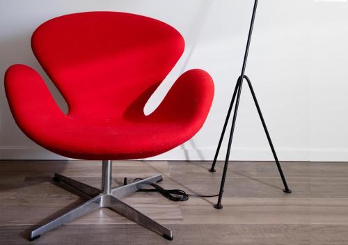 a red office chair sitting next to a lamp at Hotell Havsporten in Karlholmsbruk