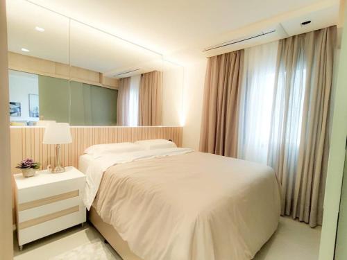 1 dormitorio con cama blanca y espejo en Saint Paul Apartment by BnbHost, en São Paulo