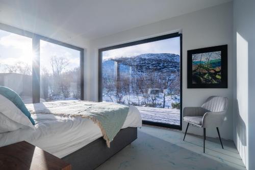 a bedroom with a bed and a large window at Aurora View Lapland, Sky View Bedroom & Jacuzzi in Kilpisjärvi