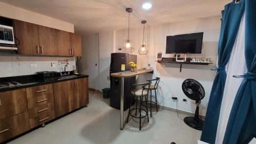 a kitchen with a black refrigerator and a counter at Andaliving Niquia Apartaestudio in Bello