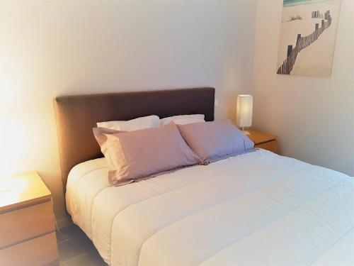 a bedroom with a bed with three pillows on it at Appartement moderne 3* avec balcon, proche du lac et plage, parking privatif, Wi-Fi inclus - FR-1-239-862 in Soorts-Hossegor