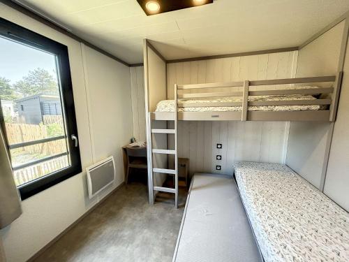 ein kleines Zimmer mit 2 Etagenbetten und einem Fenster in der Unterkunft Chalet Jullouville, 4 pièces, 7 personnes - FR-1-361-463 in Jullouville-les-Pins