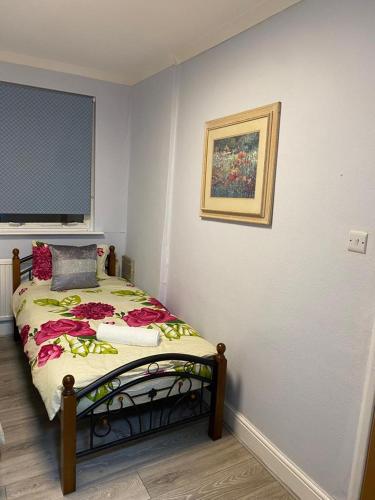 a bedroom with a bed with a painting on the wall at Ground floor Studio Flat In London in London