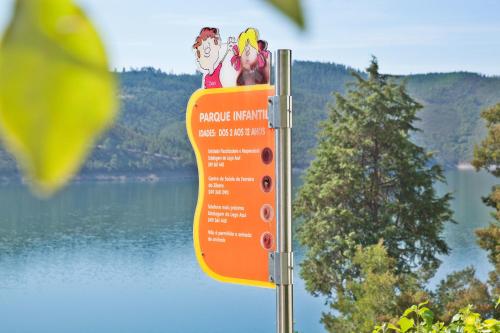 an orange sign with cartoons on top of it at Lago Azul Eco Hotel in Ferreira do Zêzere