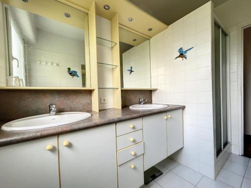 a bathroom with two sinks and two mirrors at Maison Jullouville, 6 pièces, 11 personnes - FR-1-361-466 in Jullouville-les-Pins