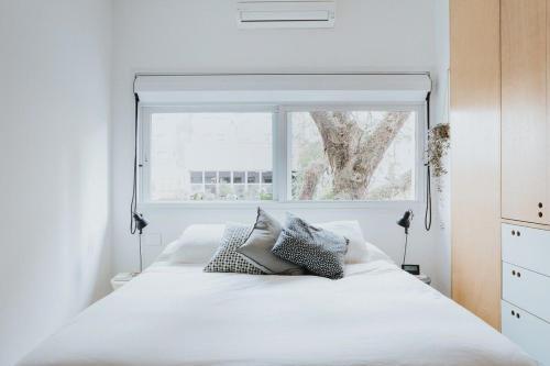 sypialnia z białym łóżkiem i oknem w obiekcie Concept Uno Apartments by BnbHost w São Paulo