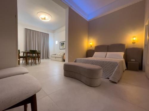 a bedroom with two beds and a couch and a table at Ritucci Suite in Lecce