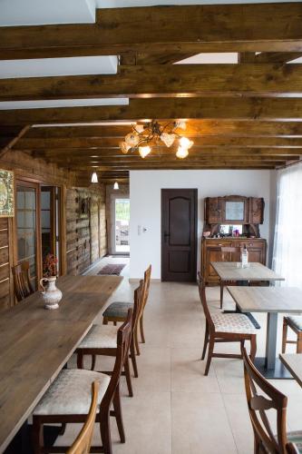 a dining room with wooden ceilings and tables and chairs at Casa cu Magnolii in Poienile Izei