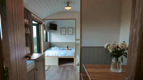 een slaapkamer met een bed en een vaas met bloemen bij Denham's Rest in Clitheroe