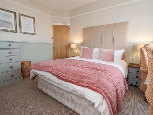 a bedroom with a large bed with a red blanket at Sea View House in Hornsea