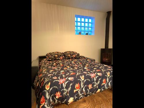 um quarto com uma cama com um edredão preto e uma janela em Maison individuelle cosy em Argenteuil