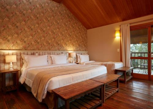Hotel Fazenda Morros Verdes Ecolodge في إبيونا: غرفة نوم بسريرين ونافذة