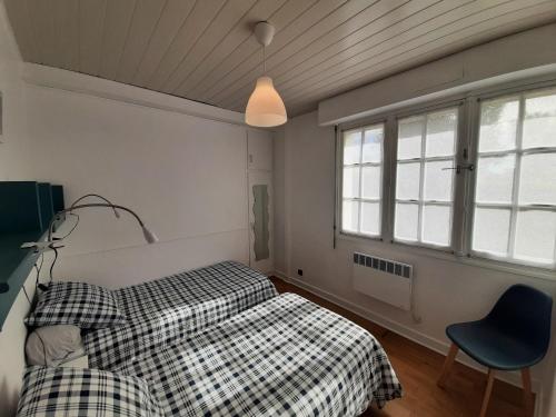 a bedroom with two beds and a chair and a window at Villa Patio Charmante, 2 Pas des Plages, Terrasse, Parking, Piste Cyclable - FR-1-239-892 in Capbreton