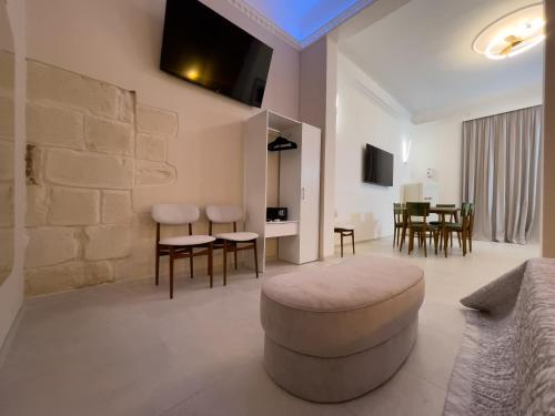 a living room with a couch and a table and chairs at Ritucci Suite in Lecce