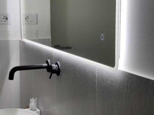 a bathroom with a mirror and a sink at Ritucci Suite in Lecce