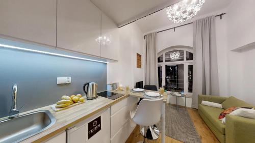 a kitchen and living room with a sink and a couch at APARTHOTEL TECTUM in Wrocław