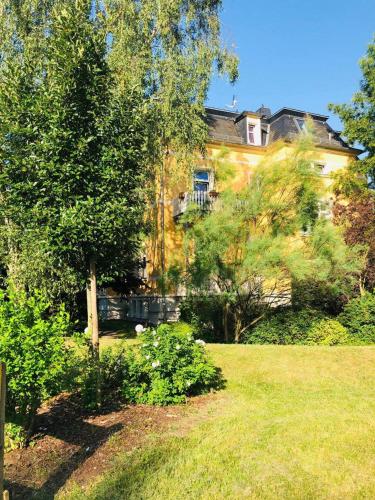 a large house with a tree and a yard at Pension&Wellness-Oase-Nossen in Nossen