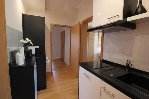 a kitchen with a black counter top and a sink at Pension&Wellness-Oase-Nossen in Nossen