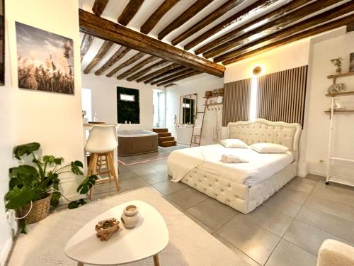 - une chambre avec un lit blanc et une table dans l'établissement Logement moderne avec jacuzzi, à Aubervilliers