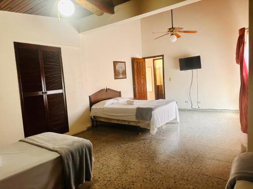 a bedroom with two beds and a ceiling fan at Villas del Mar in La Ceiba