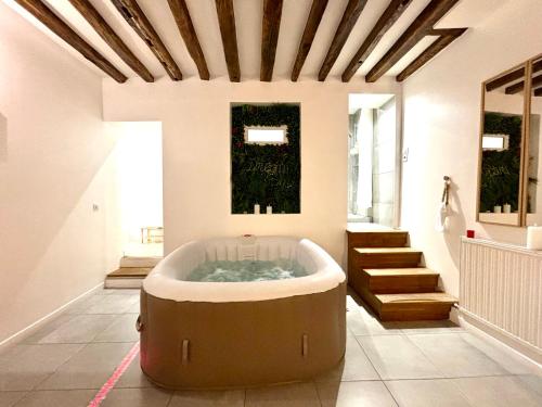 - une grande baignoire dans une chambre avec des escaliers dans l'établissement Logement moderne avec jacuzzi, à Aubervilliers