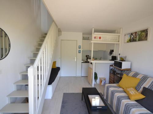 un salon avec un canapé et un escalier dans l'établissement Charmant Duplex T2 avec Balcon et Terrasse, Résidence Les Pieds dans l'Eau, Arcachon - FR-1-420-126, à Arcachon