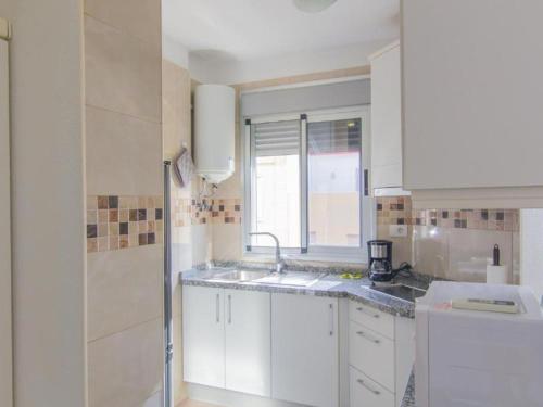 Una cocina blanca con fregadero y ventana. en Live La Laguna Heraclio, en La Laguna