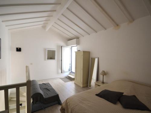 - une chambre avec des murs blancs, un lit et une fenêtre dans l'établissement Charmant Duplex T2 avec Balcon et Terrasse, Résidence Les Pieds dans l'Eau, Arcachon - FR-1-420-126, à Arcachon