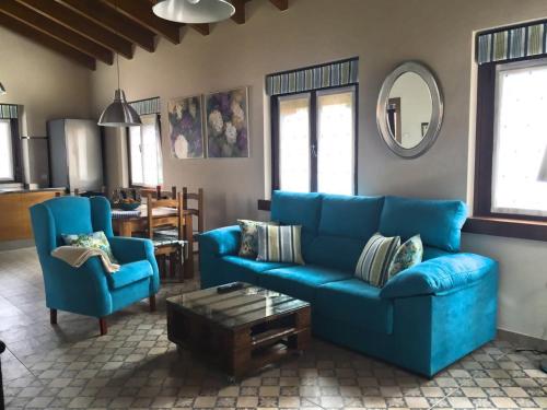 1 sofá azul y 2 sillas en la sala de estar. en La Fragua en Nueva de Llanes