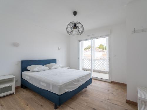 - une chambre blanche avec un lit bleu et une fenêtre dans l'établissement Appartement Neuf 3* à 100m de l'Océan avec Piscine pour 8 Personnes - Ménage Inclus - FR-1-50-113, à Mimizan