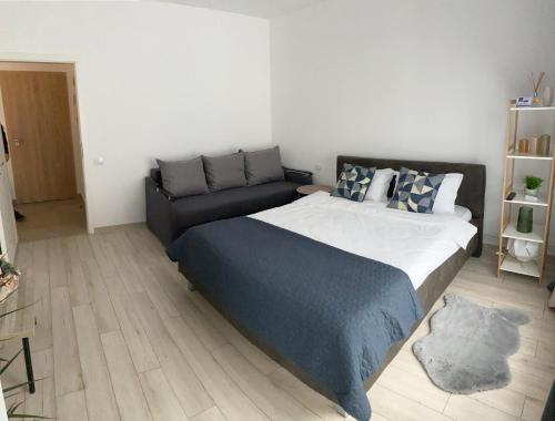 a bedroom with a large bed and a couch at Deea H24 in Râşnov