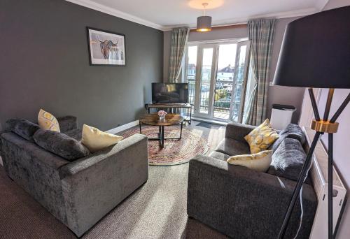 a living room with two couches and a television at Stylish Modern Apartment, FREE SECURE Parking in Allesley