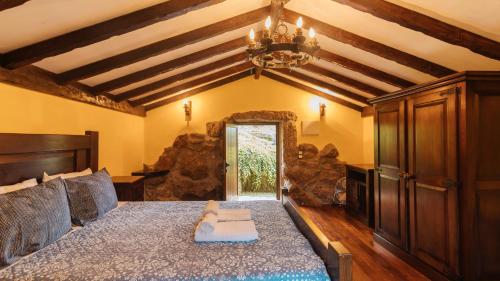 um quarto com uma cama e um lustre em Casa Quinta das Vessadas em Celorico de Basto