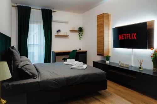 a bedroom with a bed and a tv on the wall at NEW Luxury City Center Studio in Bucharest