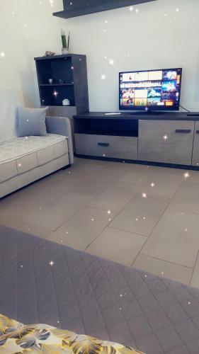 a living room with a couch and a flat screen tv at House Arrow in Latina