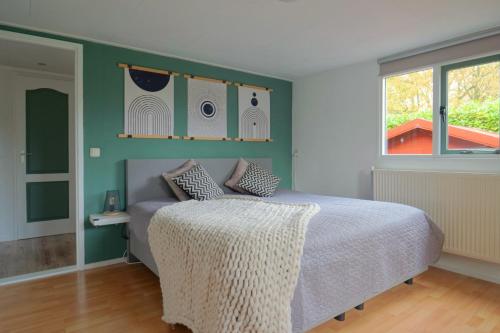 een slaapkamer met een bed en een raam bij Better together - luxe chalet met houtkachel in Erm