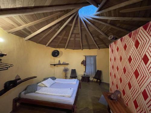 - une chambre avec un lit et un plafond en bois dans l'établissement Cantos da Mata, à Chapada dos Guimarães
