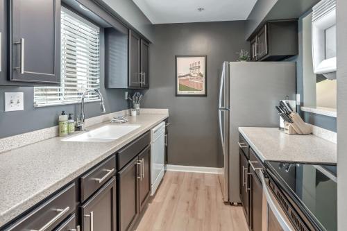 a kitchen with a sink and a refrigerator at Nashville Oasis Walk to Broadway with POOL, Parking, Gym and Patio in Nashville